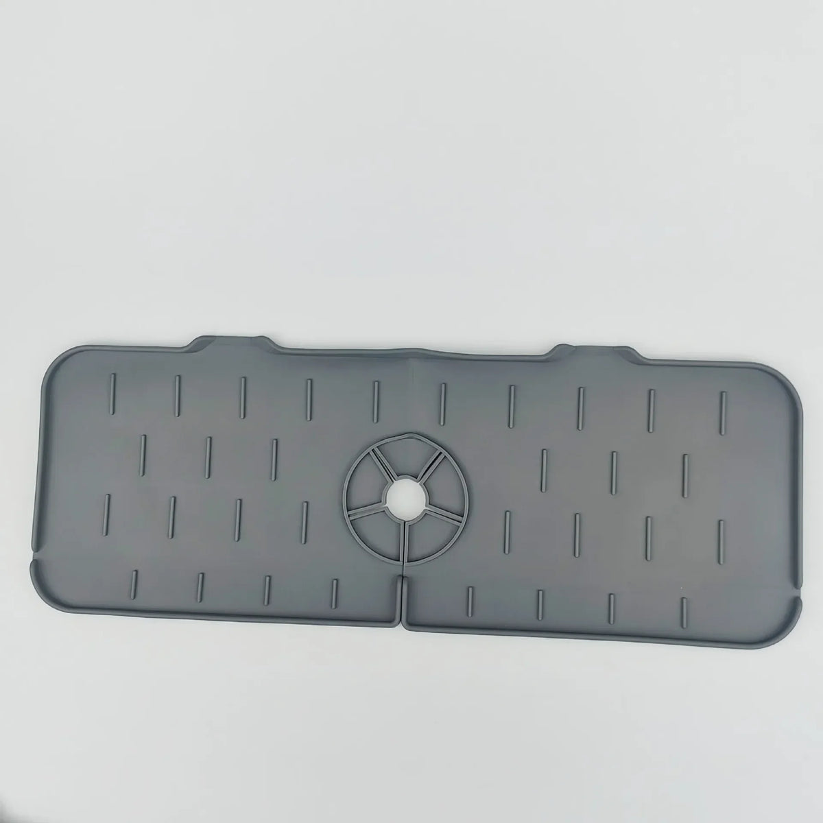 Gray silicone kitchen sink mat with drainage slots and a central faucet splash guard