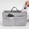 A gray purse organizer insert with multiple compartments is shown, holding a smartphone and earbuds.