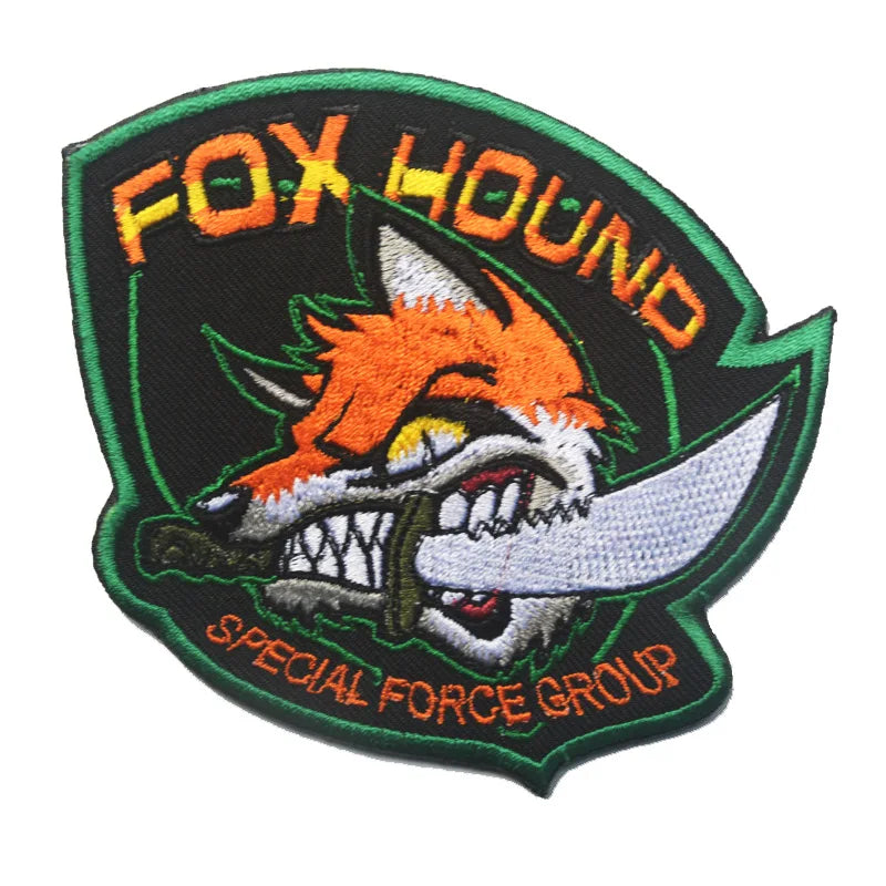 An embroidered patch featuring a stylized fox hound head with a hook and loop backing, surrounded by the text FOX HOUND and S