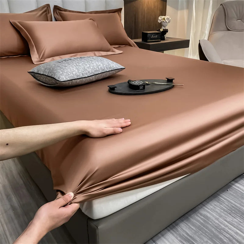 Primer plano de un lujoso juego de sábanas marrones ajustadas con almohadas y una bandeja oscura sobre la cama.