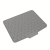 A gray silicone dish drying mat with numerous small drainage holes.