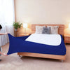 A dark blue stretch-fit box spring cover with an elastic edge placed on a wooden bed frame.