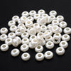 A pile of 100 white acrylic pearl spacer beads for jewelry making.