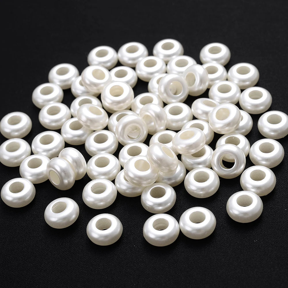 A pile of 100 white acrylic pearl spacer beads for jewelry making.