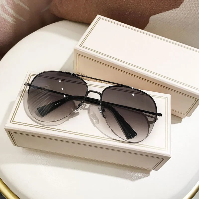 Paar klassischer Aviator-Sonnenbrille mit dunklen Linsen in einer weißen Geschenkbox.