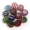 A collection of five resin rhinestone beads in various colors including pink, green, black, and multicolored designs.