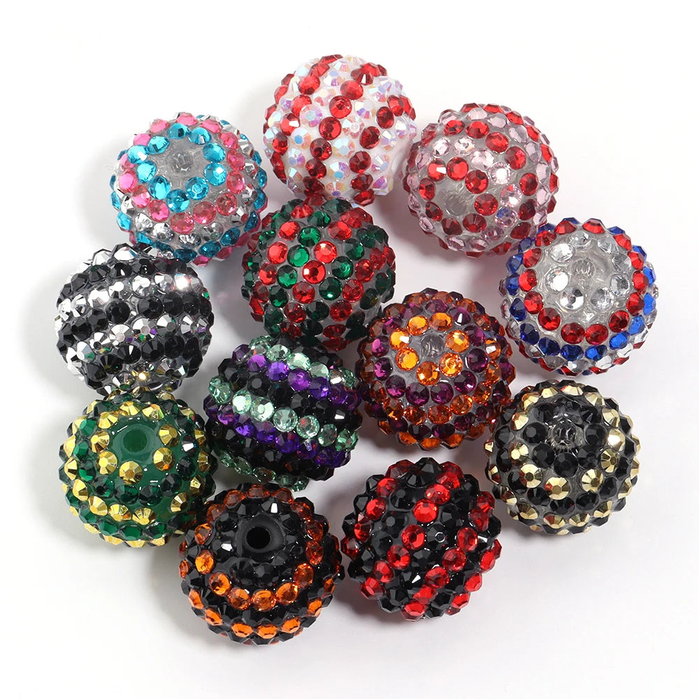 A collection of five resin rhinestone beads in various colors including pink, green, black, and multicolored designs.