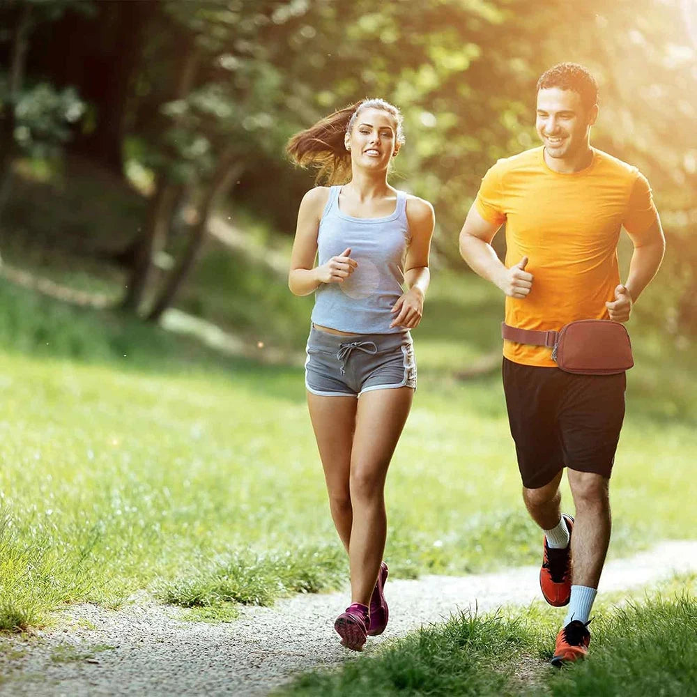 A woman and a man jogging on a path in a park, one wearing an adjustable nylon waist pack.
