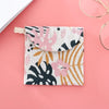 A pink and white patterned cosmetic storage pouch with a natural fiber drawstring closure is displayed on a pink background.