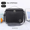 Black insulated lunch bag with a shoulder strap shown on a white surface.