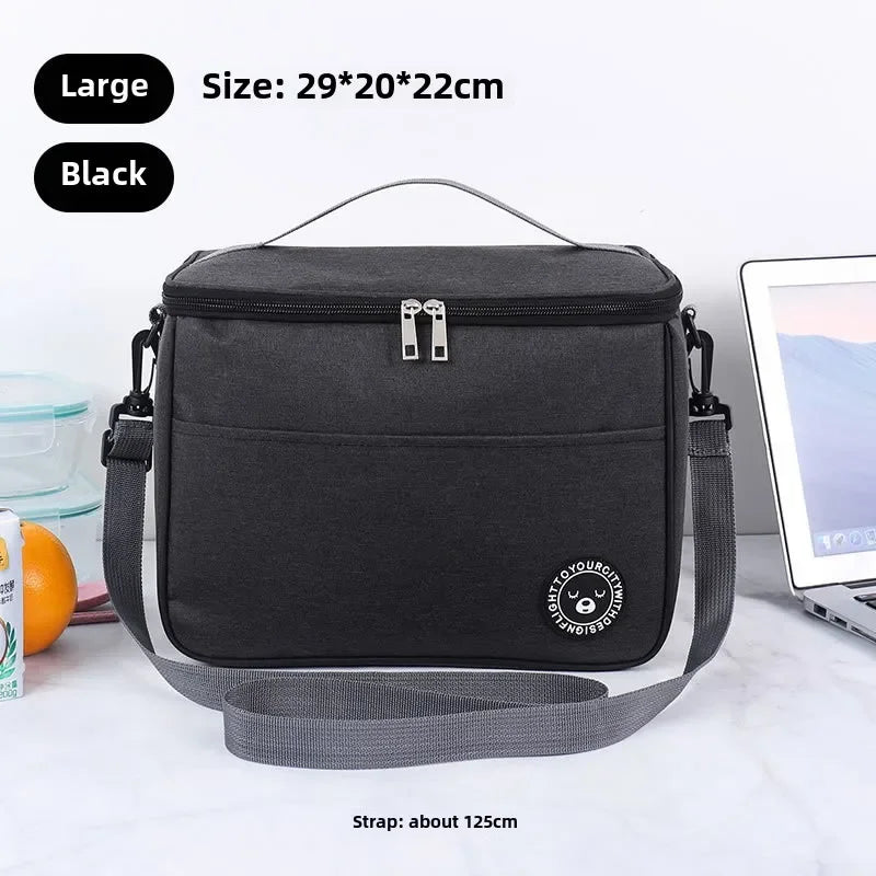 Black insulated lunch bag with a shoulder strap shown on a white surface.