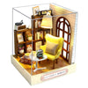 A wooden miniature dollhouse kit featuring a yellow armchair, shelves, and a wooden arched window with an illuminated lamp.