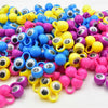 A large pile of 100 colorful eye finger puppet rings in various shades of blue, yellow, and pink for party favors.