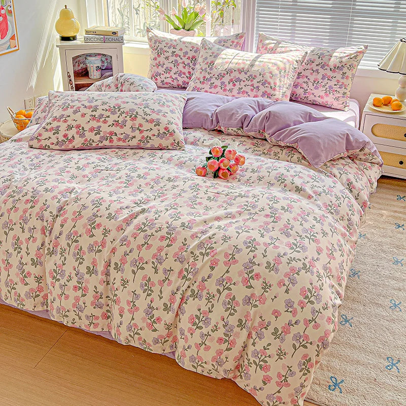 A floral duvet cover set featuring pink and purple floral patterns on a bed with matching pillows.