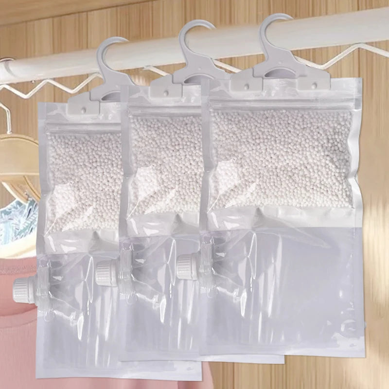 Clear reusable bags filled with white moisture absorbers hanging from a white hook.
