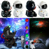 A set of astronaut night lights and a projector displaying colorful galaxy stars on a dark background.