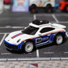 A white and blue die-cast model car, resembling a Porsche, is displayed on a black grid surface.