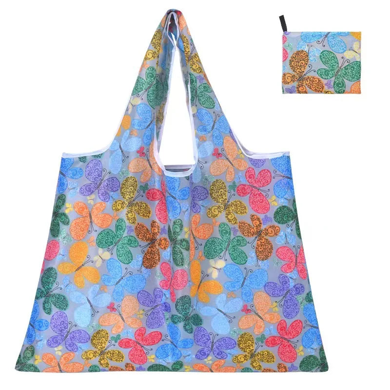 A clear reusable shopping tote bag featuring a vibrant floral pattern with orange, pink, green, and purple butterfly designs.