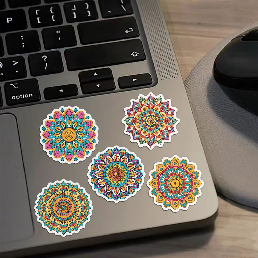 A laptop shows a collection of colorful mandala and graffiti stickers on its surface.