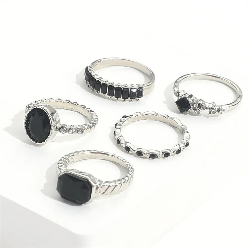 A set of vintage black crystal rings featuring various designs and settings.