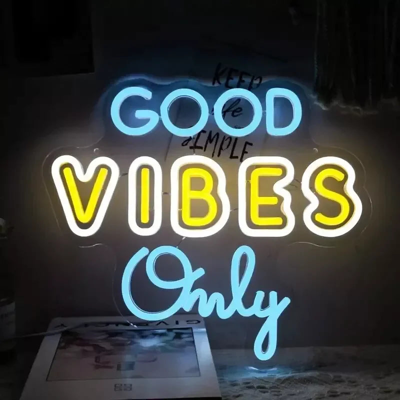 A glowing neon sign displaying the text GOOD VIBES Only on a dark background.