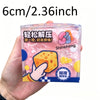 Eine Hand hält einen durchsichtigen Plastikbehälter mit einem rosa, weichen Käse-Fidget-Spielzeug mit gelben und orangen Akze