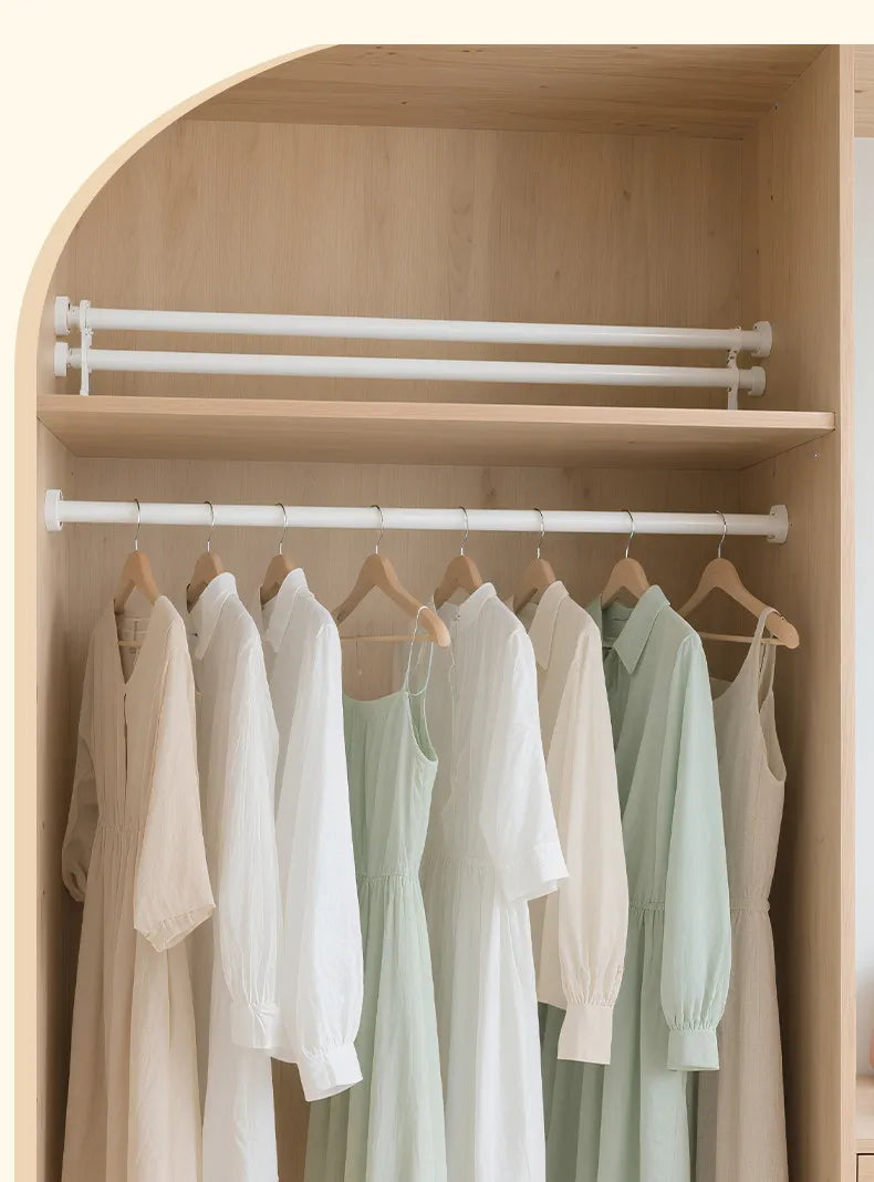 A display of white and light green clothing hanging on a wooden rack inside a shower niche.