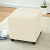 A beige, upholstered cube-shaped floor sofa cover with a quilted texture resting on a light carpet.