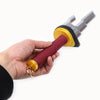 A hand holds a cosplay katana replica with a red grip and gold accents.