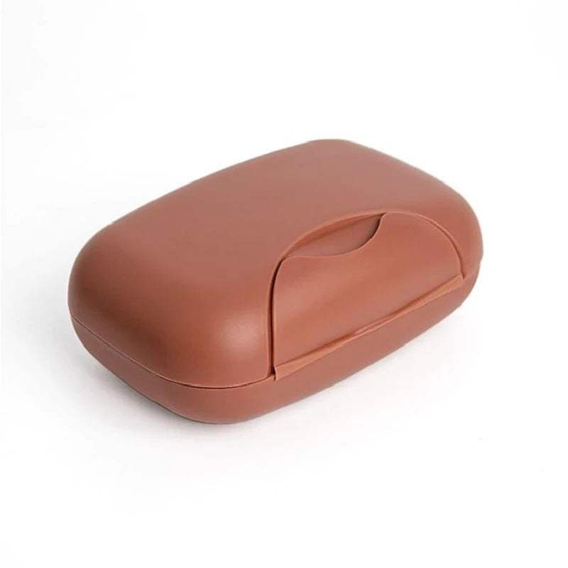 A compact, brown leak-proof travel soap box with a rounded, smooth design.