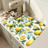 A yellow lemon print absorbent kitchen drying mat placed on a light-colored cabinet surface.