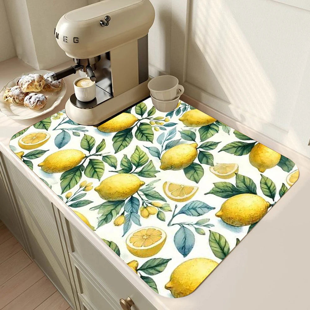 A yellow lemon print absorbent kitchen drying mat placed on a light-colored cabinet surface.