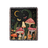 A dark forest scene featuring mushrooms and a crescent moon on a woven throw blanket.