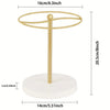 A gold-colored sunglasses organizer stand with a circular hoop and a white base.