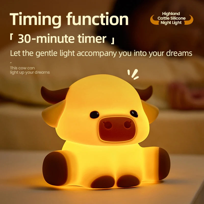 A yellow silicone night light shaped like a Highland cow, glowing softly on a surface.