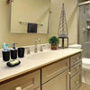 A bathroom vanity featuring a white countertop, sink, and storage cabinets with a soap dispenser and towel rack.