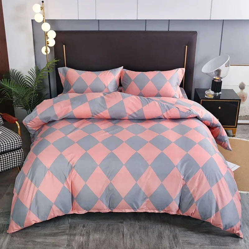 A pink and gray diamond patterned duvet cover set with matching pillowcases displayed on a bed.