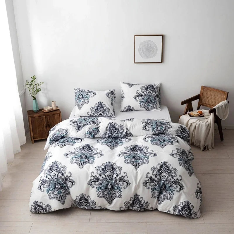 A white duvet cover set with blue and gray floral geometric pattern displayed on a bed against a white wall.