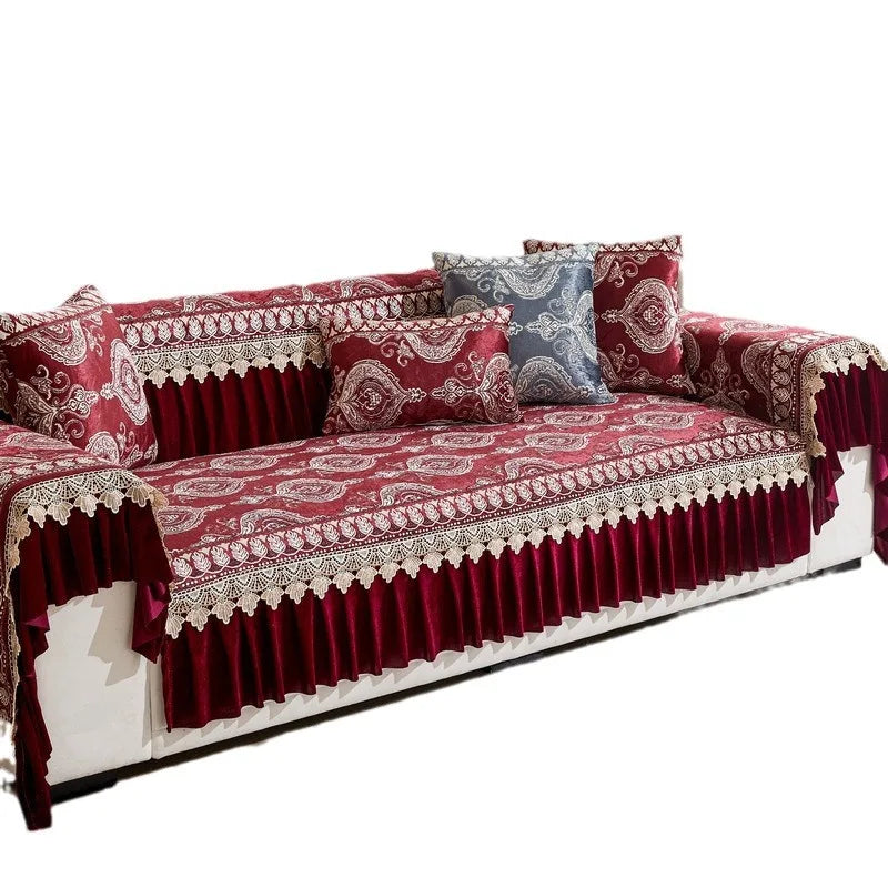A deep red embroidered sofa cover featuring quilted protection and decorative pillows.