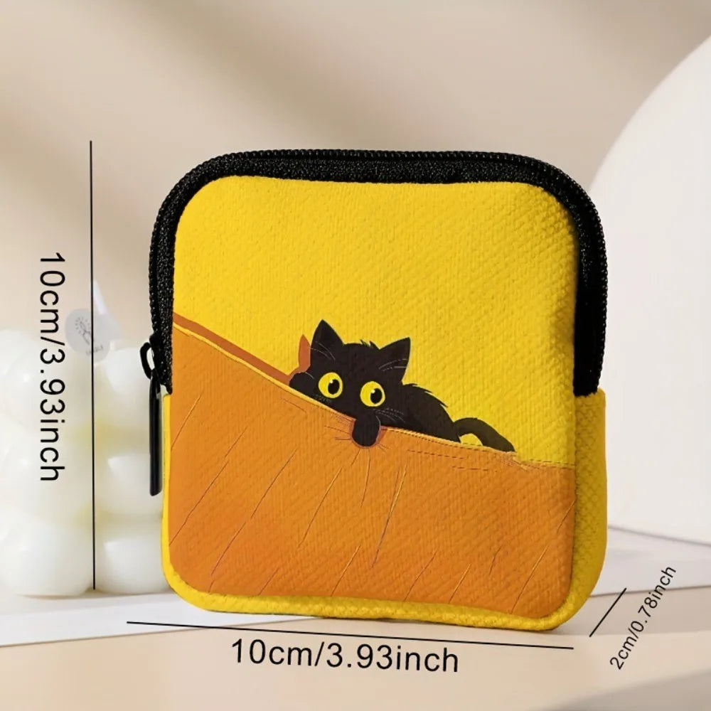 A yellow pouch featuring a black cat silhouette on an orange background, next to a white candle.