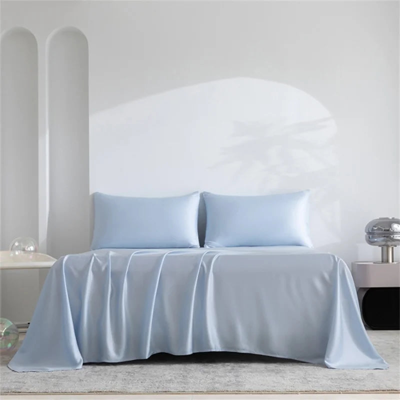 Hellblaue Luxus-Bambusbettwäsche-Set über einem Bett mit weißen Wänden drapiert.