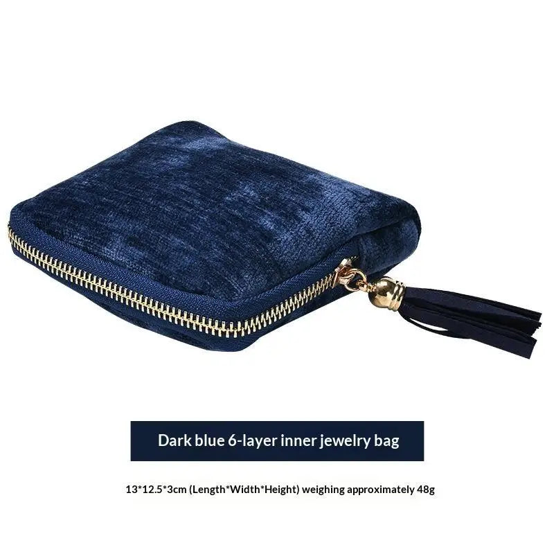Dark blue velvet jewelry bag with a gold zipper and multiple compartments