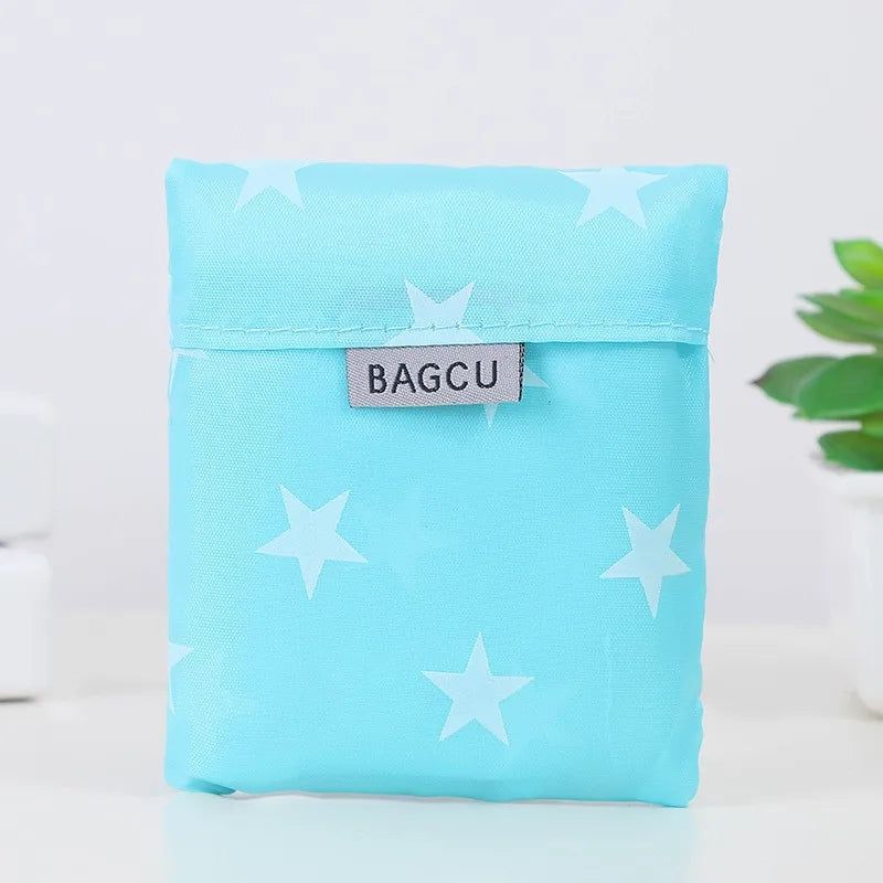 Light blue fabric pouch with white stars and a rectangular tag labeled BAGCU