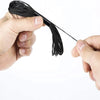 A hand holds a black embroidery floss set with a long tail against a white background.