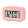 A pink compact LED digital alarm clock displaying 12:00, with a display showing month, date, day, and temperature.