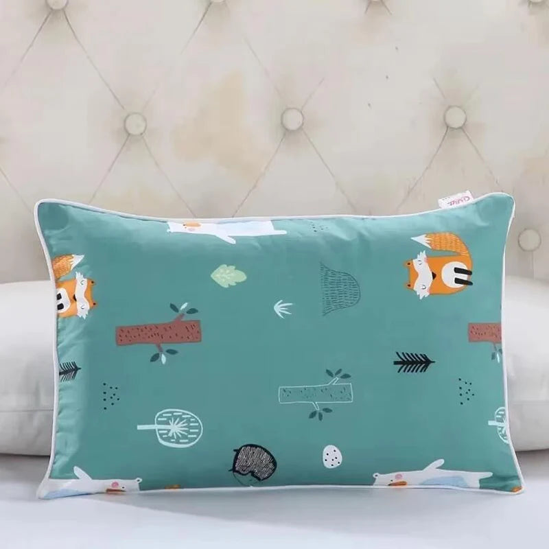 A teal cartoon pillow featuring various animal and nature motifs like a fox, leaves, and berries.