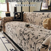 Beige bestickter Chenille-Sofa-Überzug mit schwarzen Blumen- und Vogelmustern auf hellem Stoff.