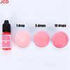 A set of fluorescent red liquid candle dye in dropper bottles showing 1, 5, and 10 drops of the pink color.