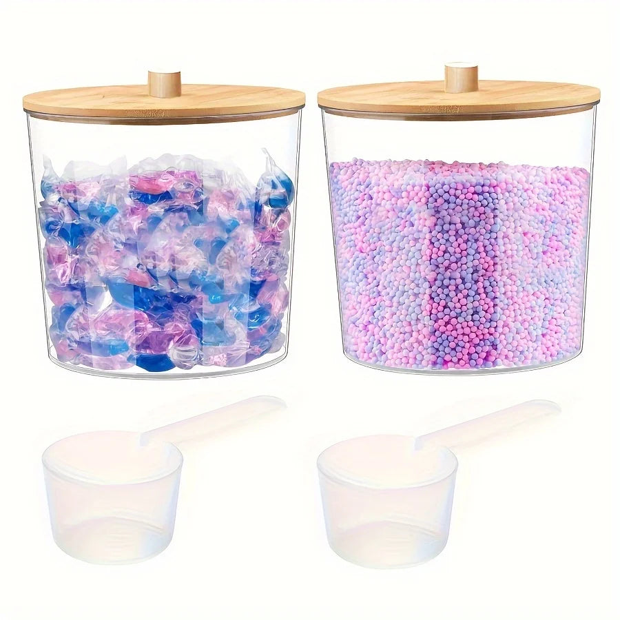 Clear acrylic detergent pod storage container with a wooden lid and a plastic spoon