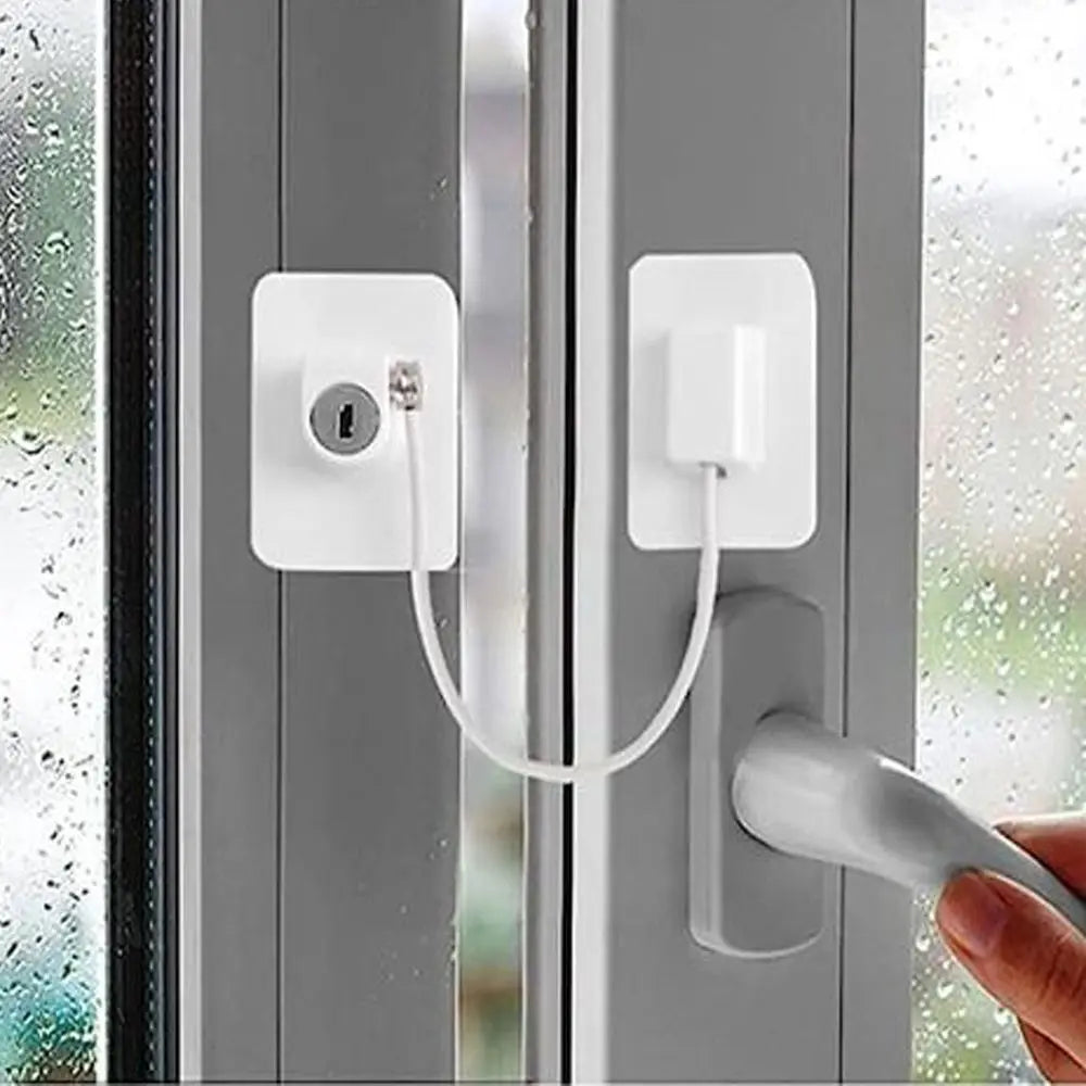 A white self-adhesive window safety lock with two keys is installed on a gray door frame.